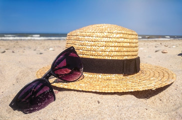 Women's beach accessories on sand for summer vacation concept.