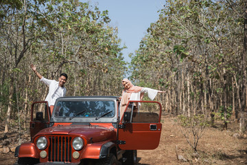 woman and man sitting on top of a car