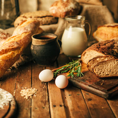 Still life. Agricultural products: eggs, milk, fresh bread on a wooden table. Close-up One trick