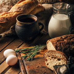 Still life. Agricultural products: eggs, milk, fresh bread on a wooden table. Close-up One trick
