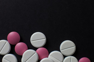  Red white tablets on a black background