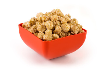 Caramel popcorn in a quadratic red plate, isolated on white background