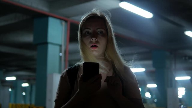 Young blond girl see something strange and horrible behind here at the night parking place