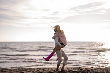 Loving young couple on a beach at autumn sunny day
