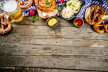 Oktoberfest food menu, bavarian sausages with pretzels, mashed potato, sauerkraut, beer bottle and mug old rustic wooden background, copy space above