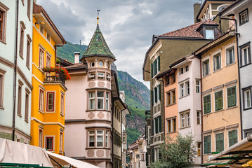 Colorful historic buildings in the city center of Bolzano with high mountains in the background