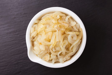 Homemade caramelized onions in frying pan. Vegetarian food..