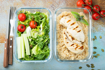 Healthy meal prep containers with quinoa, chicken breast and green salad overhead shot. Top view. Flat lay