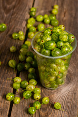 ggooseberries in plastic glasses on a wooden table