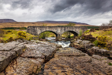 Fototapeta na wymiar Old stone bridge over a creek in the scottish highlands