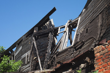 Ruined building after a fire. Wall of a wooden burnt house