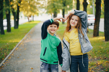 Children holding hands in autumn park.