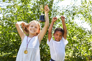 Zwei Kinder mit Sieger Pokal und Medaille