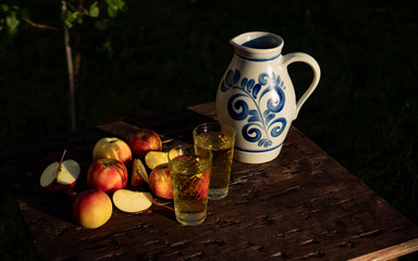 Traditional apple wine in the city of Frankfurt in Hesse. A jug of wine is on an old wooden table...