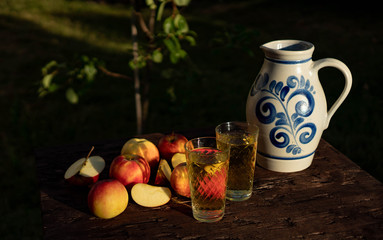 Traditional apple wine in the city of Frankfurt in Hesse. A jug of wine is on an old wooden table...