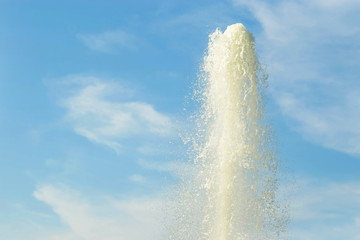 water fountain on the background of a gentle blue sky with clouds