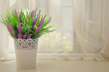 Beautiful artificial bouquet with lavender on the window