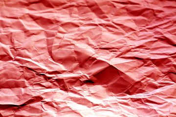 Crumpled sheet of paper with blur effect in red tone.