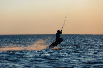 professional kiter doing a complicated trick on a beautiful sunset background