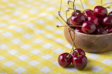 Fresh cherries  on yellow background  with copy space. Summer and harvest concept.