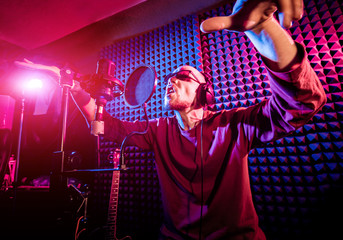 The singer sings with a microphone in the recording studio. - obrazy, fototapety, plakaty