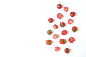 Bunch of beautiful juicy organic red cherry tomatoes whole & halved on white background. Top view of shiny polished vegetables. Clean eating concept. Vegetarian vegan detox diet. Copy space, flat lay.