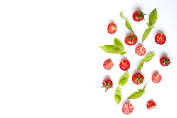 Bunch of beautiful juicy organic red cherry tomatoes, green basil leaves on white background. Shiny polished glossy vegetables. Clean eating concept. Vegetarian diet. Copy space, flat lay, top view.