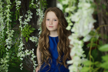 Naklejka premium happy little girl holding decorative bird cage full of flowers. Studio shot in provence style interior
