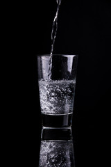 Bubbly drink in a glass on a black background