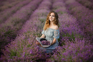 Beautiful woman in a field of lavender. Woman in amazing dress walk on the lavender field.