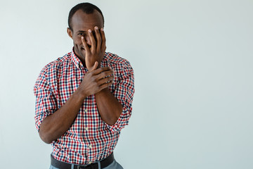 Cheerful afro american man holding his hand on the face