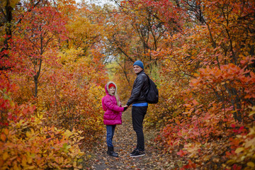 Obraz premium portrait of pretty little girl and young father walking in beautiful autumn park