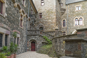 Fototapeta na wymiar Old, stone castle courtyard with wooden door in the background
