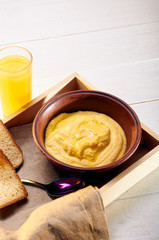 Polenta with butter and some crispy toast. Orange freshly squeezed juice and food on a tray for breakfast in bed. Simple and delicious food for an early morning before work.
