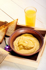 Polenta with butter and some crispy toast. Orange freshly squeezed juice and food on a tray for breakfast in bed. Simple and delicious food for an early morning before work.