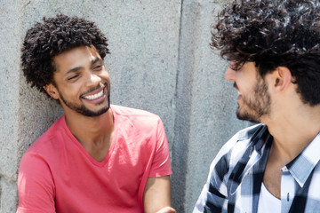 Happy african american man talking with friend - Powered by Adobe