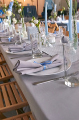 The chic restaurant is ready to receive guests. Blurred people in the background. Everything is ready for the wedding, celebrating the birthday, christening, another celebration.