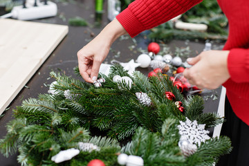 A woman decorates a Christmas wreath. Hands close-up. Master class on making decorative ornaments....