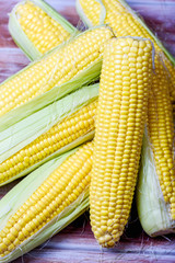 Ripe and sweet corn on a wooden background