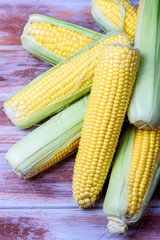 Ripe and sweet corn on a wooden background
