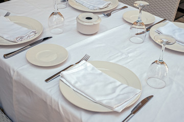 restaurant table with empty plates napkins cutlery and glasses