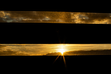Obraz premium Czarna roleta przebija zachód słońca
