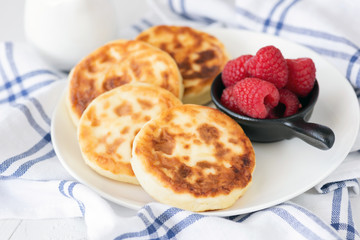 Cottage cheese pancakes on white plate. Also known as syrniki, sirniki or cottage cheese fritters....