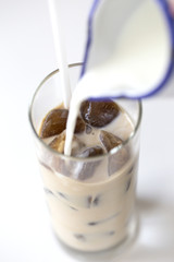 Iced coffee cocktail or frappe with ice cubes and cream