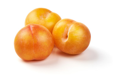 Juicy yellow plums, isolated on white background.