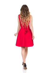 Walking Woman In High Heels And Red Dress. Rear View.