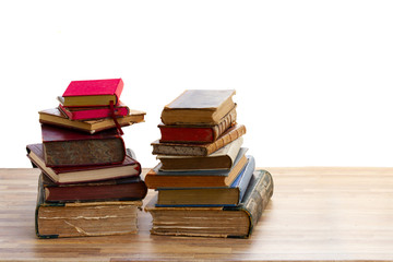 Stacks of old books with open one on wooden shelf over white background