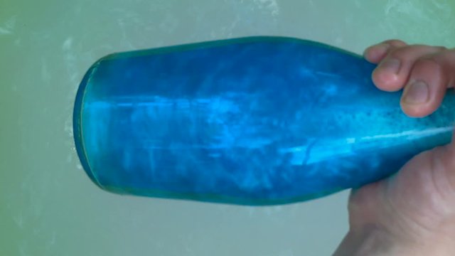 Blue elixir bottle pulled from the water