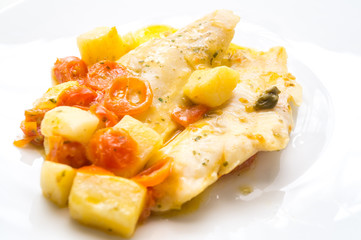 fish dish, cod with tomato, potatoes and capers, cooked in a pan.