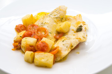 fish dish, cod with tomato, potatoes and capers, cooked in a pan.